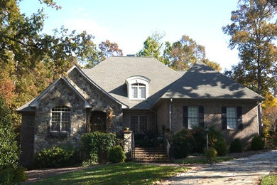 Mid-sized two-story brick exterior home photo in Other with a clipped gable roof