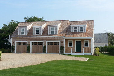 Example of a large beach style beige two-story wood exterior home design in Boston with a shingle roof