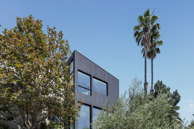 Inspiration for a mid-sized modern gray two-story wood house exterior remodel in Los Angeles with a shed roof and a mixed material roof