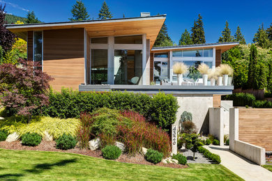Diseño de fachada de casa actual grande de dos plantas con revestimiento de madera y tejado de un solo tendido