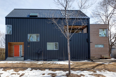 Idéer för ett modernt svart flerfamiljshus, med två våningar, blandad fasad, pulpettak och tak i mixade material