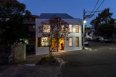 Cette photo montre une façade de maison grise tendance en brique de taille moyenne et à deux étages et plus avec un toit en métal.