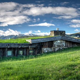 Idée de décoration pour une façade de maison marron chalet de taille moyenne et de plain-pied avec un revêtement mixte, un toit à deux pans et un toit végétal.