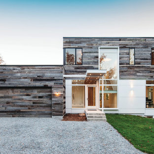 Diseño de fachada blanca, moderna, grande, de dos plantas, con revestimiento de madera y tejado plano