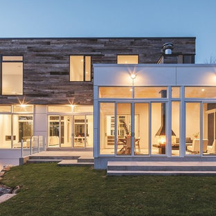 Foto de fachada blanca, minimalista, grande, de tres plantas, con revestimiento de madera y tejado plano