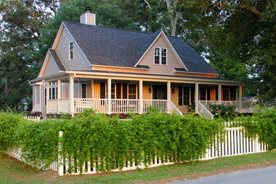 Ejemplo de fachada beige de estilo de casa de campo de tamaño medio de dos plantas con revestimiento de madera