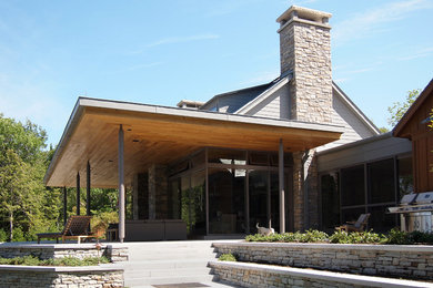 Foto de fachada de casa gris actual de tamaño medio de una planta con revestimientos combinados, tejado a dos aguas y tejado de teja de madera