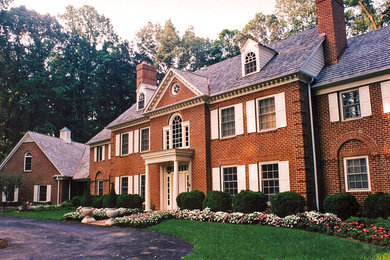 Cette photo montre une grande façade de maison rouge chic en brique à deux étages et plus avec un toit à deux pans et un toit en shingle.