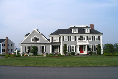 Diseño de fachada de casa gris tradicional grande de tres plantas con revestimiento de aglomerado de cemento, tejado a cuatro aguas y tejado de teja de madera