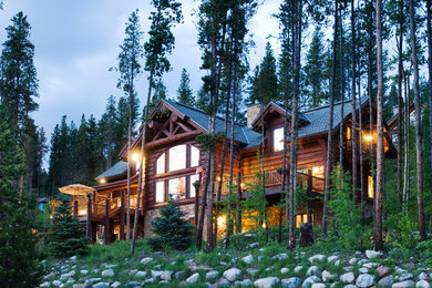 Example of a large mountain style brown three-story wood exterior home design in Other with a shingle roof