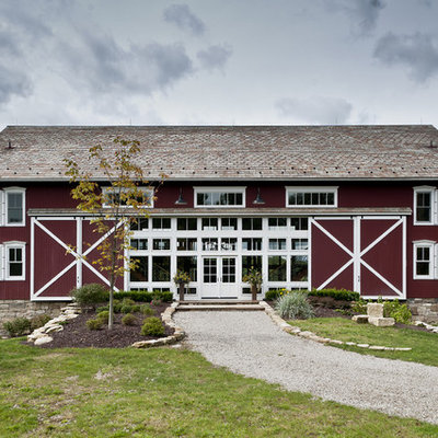 Example of a large farmhouse three-story wood exterior home design in Cleveland