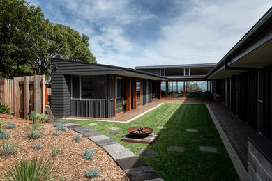 Foto de fachada de casa de tamaño medio de dos plantas con revestimientos combinados y tejado de metal