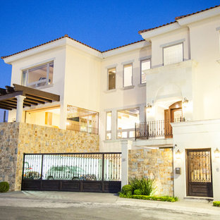 Ejemplo de fachada de casa amarilla, mediterránea, grande, de tres plantas, con revestimiento de hormigón y tejado de teja de barro