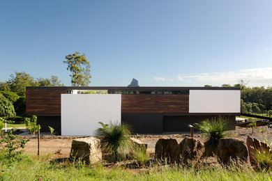 Diseño de fachada marrón moderna de tamaño medio de dos plantas con revestimientos combinados y tejado plano