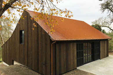 Exemple d'une façade de maison nature en bois avec un toit à deux pans et un toit en métal.