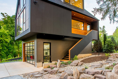 Imagen de fachada de casa marrón moderna de tamaño medio de tres plantas con revestimientos combinados