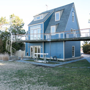 Modelo de fachada azul, moderna, grande, de tres plantas, con revestimiento de madera y tejado a dos aguas
