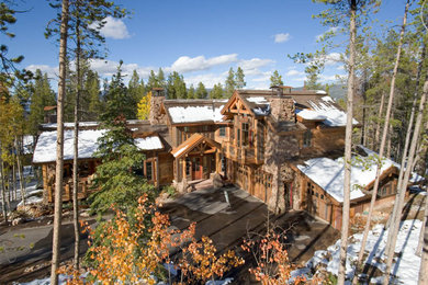 Example of a large mountain style brown three-story wood exterior home design in Denver with a mixed material roof
