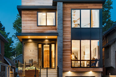 Réalisation d'une façade de maison marron design en bois à un étage avec un toit plat.