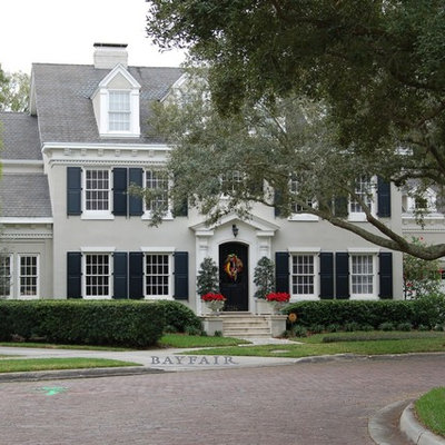 Example of a large classic gray three-story stucco exterior home design in Tampa with a shingle roof