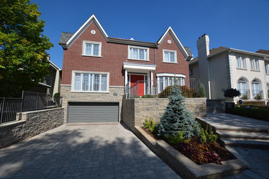 Photo of a medium sized and red classic two floor brick house exterior in Toronto.