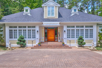 Example of a large transitional yellow two-story wood house exterior design in Raleigh with a hip roof and a shingle roof