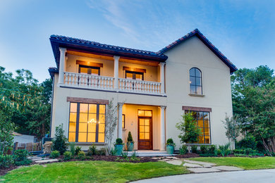 This is an example of a large and beige mediterranean two floor house exterior in Dallas.