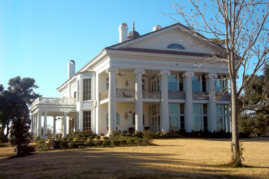 Foto de fachada de casa blanca clásica grande de tres plantas con revestimiento de estuco, tejado a dos aguas y tejado de teja de madera