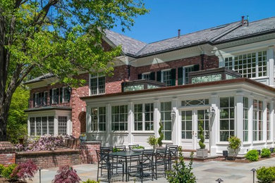 Large elegant white two-story brick exterior home photo in Boston with a mixed material roof