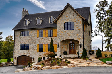 Diseño de fachada de casa beige rústica grande de tres plantas con revestimiento de piedra, tejado a dos aguas y tejado de teja de madera
