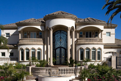 Diseño de fachada mediterránea extra grande con revestimiento de estuco y tejado a cuatro aguas