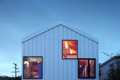 Foto de fachada blanca minimalista grande de dos plantas con revestimiento de metal y tejado a dos aguas