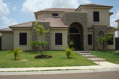 Modelo de fachada de casa beige clásica de tamaño medio de dos plantas con revestimientos combinados, tejado a cuatro aguas y tejado de teja de barro