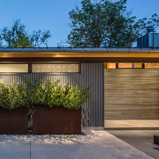Ejemplo de fachada de casa azul, contemporánea, de tamaño medio, de dos plantas, con revestimiento de metal, tejado plano y tejado de metal