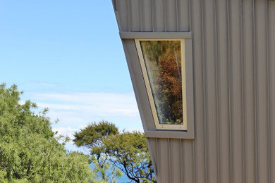 オークランドにあるコンテンポラリースタイルのおしゃれな家の外観 (メタルサイディング) の写真