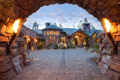 Example of a large mountain style brown stone exterior home design in Other