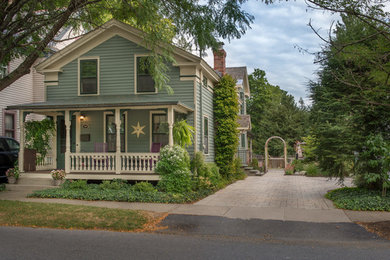 Foto della facciata di una casa verde american style a due piani di medie dimensioni con rivestimento in legno e tetto a capanna