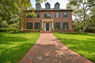 Inspiration for a large timeless three-story brick exterior home remodel in Austin with a hip roof
