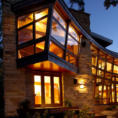 Example of a large trendy beige two-story stone flat roof design in Minneapolis
