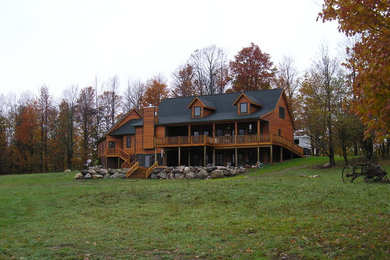Mid-sized mountain style brown two-story wood gable roof photo in Other