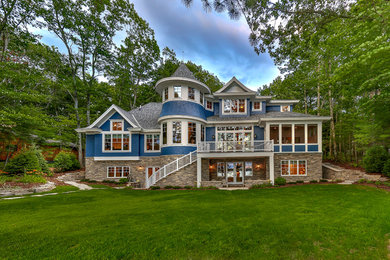Foto de fachada de casa azul tradicional grande de dos plantas con revestimiento de madera y tejado de teja de madera