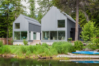 Modelo de fachada gris rural de tamaño medio de dos plantas con revestimientos combinados, tejado a dos aguas y tejado de metal
