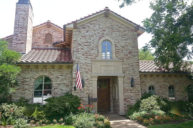 Ejemplo de fachada de casa beige de estilo americano de tamaño medio de dos plantas con revestimiento de ladrillo, tejado a dos aguas y tejado de teja de barro