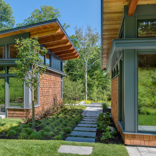 Small contemporary brown one-story wood exterior home idea in Burlington with a shed roof