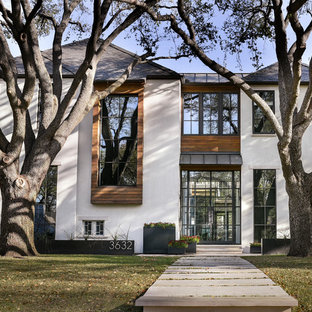 Modelo de fachada beige, contemporánea, grande, de dos plantas, con revestimiento de piedra y tejado a cuatro aguas