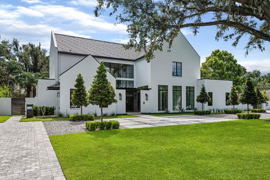 Diseño de fachada de casa blanca minimalista de dos plantas con revestimiento de ladrillo y tejado a dos aguas