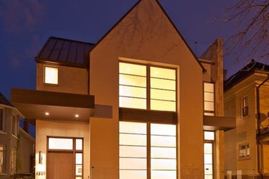 Ejemplo de fachada beige contemporánea de tamaño medio de dos plantas con revestimiento de estuco y tejado a dos aguas