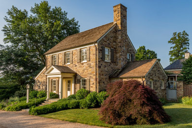 Example of a cottage brown two-story stone exterior home design in Other with a shingle roof