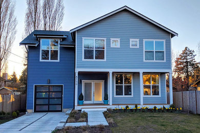 Diseño de fachada de casa azul minimalista grande de dos plantas con revestimiento de madera, tejado a dos aguas y tejado de teja de madera
