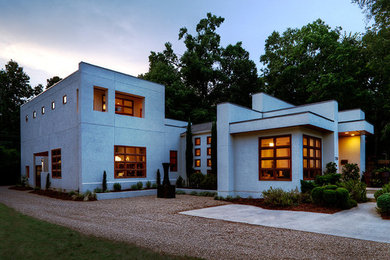 Example of a mid-sized minimalist white two-story stucco exterior home design in Charlotte with a metal roof